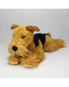 Liegender Pl&uuml;schtier Hund, der die realit&auml;tsnahe Abbildung eines Airedale Terrier ist.